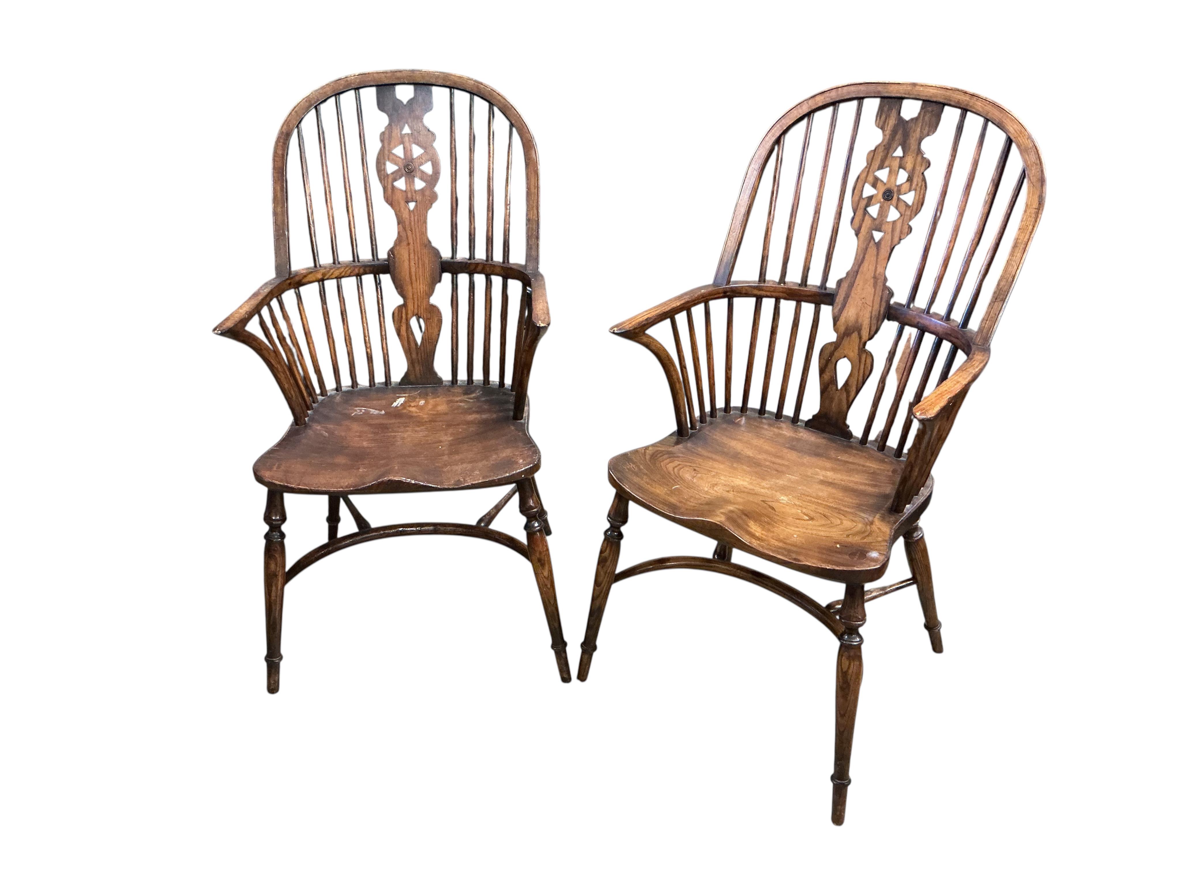 A set of ten reproduction Windsor elm and beech dining chairs with pierced splats and crinoline stretchers, two with arms